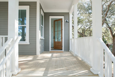 Design ideas for a mid-sized traditional front yard verandah in Charleston with decking and a roof extension.