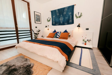 他の地域にある中くらいなモダンスタイルのおしゃれな主寝室 (白い壁、ラミネートの床、グレーの床)