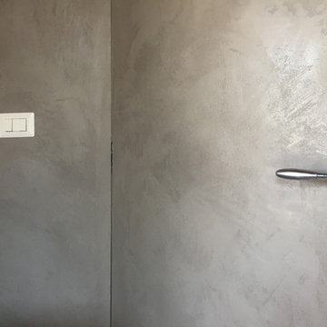 Stucco Moderno su parete con porta a filo muro e cassetti.