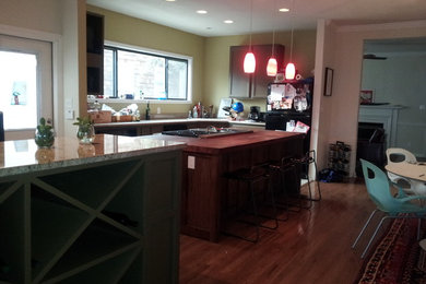 Mid-sized mountain style l-shaped travertine floor and beige floor eat-in kitchen photo in Austin with shaker cabinets, dark wood cabinets, wood countertops, stainless steel appliances and an island