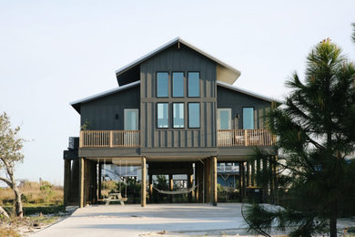 Example of a mid-sized beach style black one-story concrete fiberboard and board and batten exterior home design in Nashville with a metal roof