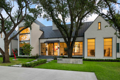 Large transitional two-story brick house exterior photo in Dallas with a hip roof and a metal roof