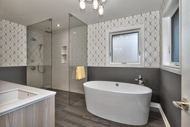 Design ideas for a mid-sized modern master bathroom in Toronto with a freestanding tub, a curbless shower, blue tile and grey walls.