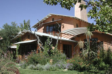Large mediterranean pink two-story stucco exterior home idea in San Francisco with a metal roof