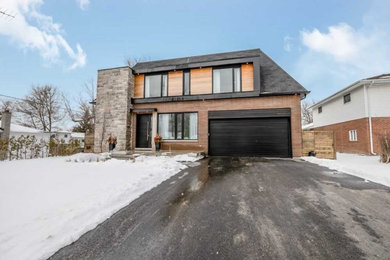 Inspiration for a mid-sized contemporary red two-story mixed siding exterior home remodel in Toronto with a mixed material roof