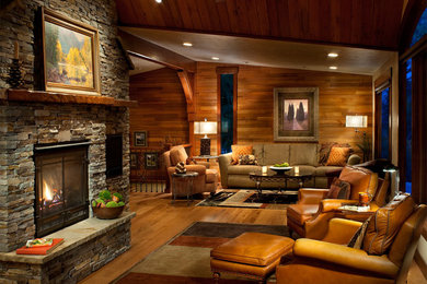 Example of an arts and crafts open concept medium tone wood floor living room design in Other with brown walls, a standard fireplace and a stone fireplace
