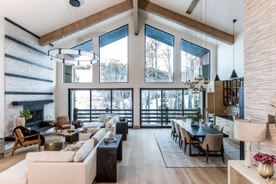 Photo of a country open concept living room in Los Angeles with white walls, light hardwood floors, a standard fireplace, beige floor, exposed beam and vaulted.