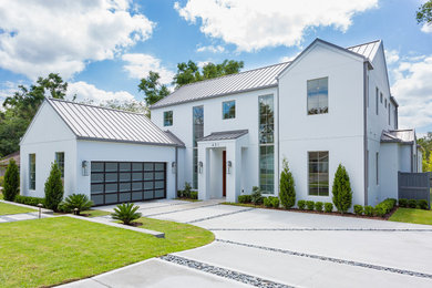 Photo of a large transitional two-storey stucco white house exterior in Orlando with a gable roof, a metal roof and a grey roof.