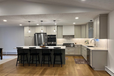 Design ideas for a large transitional l-shaped eat-in kitchen in Cleveland with an undermount sink, shaker cabinets, grey cabinets, quartz benchtops, beige splashback, ceramic splashback, stainless steel appliances, vinyl floors, with island, brown floor and white benchtop.