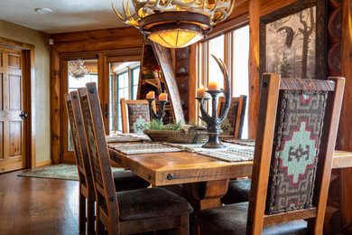 Example of a mid-sized mountain style medium tone wood floor, brown floor and wood wall dining room design in Other with brown walls