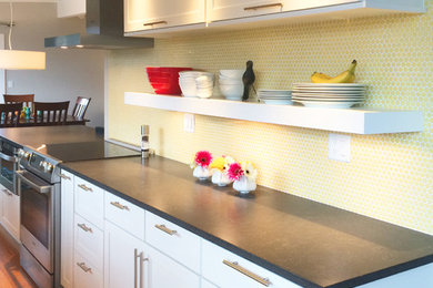 Example of a small 1950s galley bamboo floor open concept kitchen design in Other with an undermount sink, shaker cabinets, white cabinets, quartz countertops, yellow backsplash, ceramic backsplash, stainless steel appliances and a peninsula