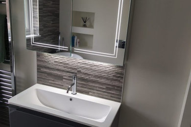 Photo of a medium sized contemporary family bathroom in Buckinghamshire with flat-panel cabinets, dark wood cabinets, a freestanding bath, a corner shower, a one-piece toilet, brown tiles, cement tiles, painted wood flooring, a sliding door, a single sink and a floating vanity unit.
