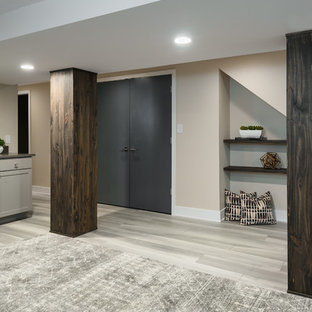 This is an example of a medium sized modern walk-out basement in St Louis with green walls, vinyl flooring and grey floors.