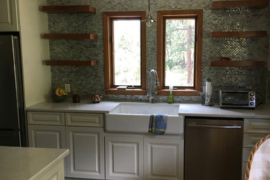 Example of a mid-sized country kitchen design in Denver with a farmhouse sink, raised-panel cabinets, white cabinets, quartz countertops, glass tile backsplash and stainless steel appliances