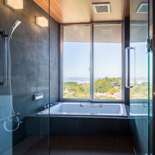 Esempio di una stanza da bagno minimalista con vasca ad angolo, doccia aperta, pareti grigie, pavimento grigio e doccia aperta