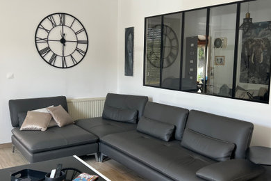 Imagen de salón cerrado y gris y negro industrial grande sin chimenea con paredes blancas, suelo de baldosas de cerámica y televisor independiente