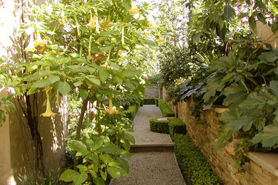 Photo of a mediterranean side yard stone landscaping in Orange County.