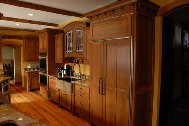 Inspiration for a large traditional l-shaped open plan kitchen in Chicago with a farmhouse sink, shaker cabinets, granite benchtops, yellow splashback, with island, brown floor, light wood cabinets, panelled appliances, light hardwood floors and beige benchtop.