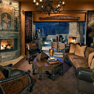 Großes, Offenes, Repräsentatives, Fernseherloses Mediterranes Wohnzimmer mit Eckkamin, Travertin, Kaminsims aus Stein, beigem Boden und brauner Wandfarbe in Phoenix