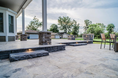 Imagen de patio grande en patio trasero con adoquines de piedra natural