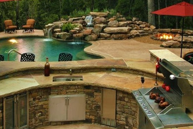 Mid-sized mountain style backyard stone patio kitchen photo in Boston with no cover