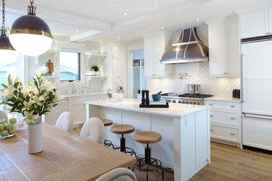 Mid-sized trendy u-shaped light wood floor eat-in kitchen photo in Calgary with an undermount sink, white cabinets, quartzite countertops, white backsplash, stainless steel appliances and an island