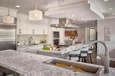Design ideas for an expansive contemporary u-shaped eat-in kitchen in San Francisco with a single-bowl sink, recessed-panel cabinets, white cabinets, quartz benchtops, white splashback, mosaic tile splashback, stainless steel appliances, dark hardwood floors, with island, brown floor and white benchtop.