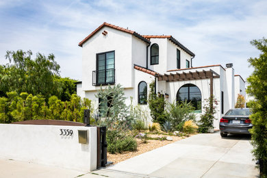 Mid-sized tuscan white two-story stucco exterior home photo in Los Angeles with a tile roof