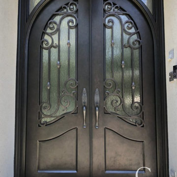 Small Transom Complementing a Stately Set of Iron Doors