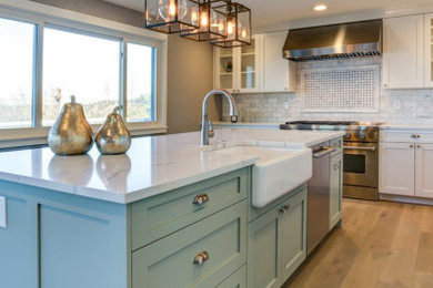 Large cottage u-shaped medium tone wood floor and brown floor eat-in kitchen photo in Detroit with a farmhouse sink, recessed-panel cabinets, white cabinets, quartz countertops, gray backsplash, ceramic backsplash, stainless steel appliances, an island and white countertops