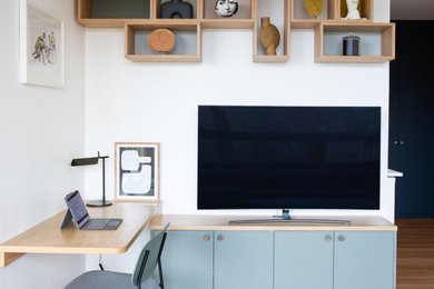 Réalisation d'un bureau design en bois de taille moyenne avec un mur multicolore, parquet clair et un bureau intégré.