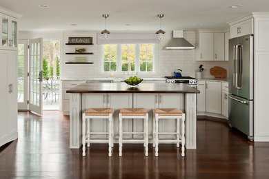 Kitchen - contemporary l-shaped kitchen idea in Boston with shaker cabinets, white cabinets, white backsplash, subway tile backsplash and stainless steel appliances