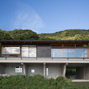 他の地域のエクレクティックスタイルのおしゃれな二階建ての家 (黒い外壁、切妻屋根、戸建、金属屋根) の写真