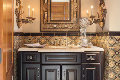 Example of a classic multicolored tile medium tone wood floor powder room design in Phoenix with an undermount sink, recessed-panel cabinets, beige walls and beige countertops