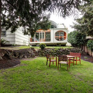 Photo of an eclectic backyard garden in Portland with with rock feature.