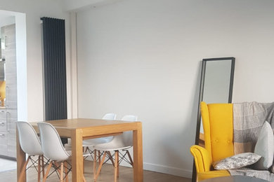 Aménagement d'une grande salle de séjour contemporaine ouverte avec un mur blanc, parquet clair, un sol beige et un plafond décaissé.