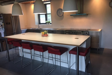アムステルダムにあるモダンスタイルのおしゃれなキッチン (一体型シンク、フラットパネル扉のキャビネット、ステンレスキャビネット、ステンレスカウンター) の写真