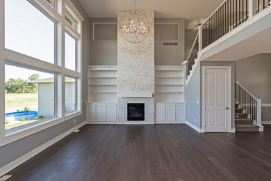Large trendy open concept medium tone wood floor family room photo in Other with gray walls, a standard fireplace, a stone fireplace and no tv
