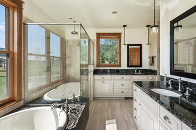 Inspiration for a large transitional master travertine tile travertine floor and beige floor bathroom remodel in Other with beaded inset cabinets, dark wood cabinets, a two-piece toilet, white walls, an undermount sink, granite countertops and a hinged shower door