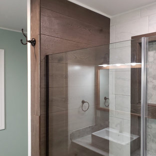 Ejemplo de cuarto de baño con ducha, único y de pie, rústico, de tamaño medio, con armarios con paneles empotrados, puertas de armario blancas, ducha empotrada, sanitario de dos piezas, baldosas y/o azulejos grises, baldosas y/o azulejos de mármol, paredes verdes, suelo laminado, lavabo sobreencimera, encimera de cuarcita, suelo marrón, ducha con puerta con bisagras y encimeras grises