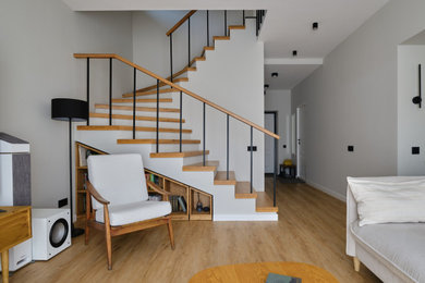На фото: угловая бетонная лестница среднего размера в скандинавском стиле с деревянными ступенями и деревянными перилами
