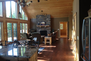 Inspiration for a mid-sized craftsman open concept dark wood floor living room remodel in Other with green walls, a standard fireplace and a stone fireplace
