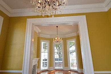 Living room - large victorian open concept medium tone wood floor living room idea in New Orleans with yellow walls, a standard fireplace and a plaster fireplace