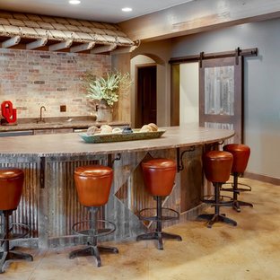 Imagen de bar en casa con barra de bar campestre con encimera de cemento, salpicadero de ladrillos, suelo de cemento y suelo beige