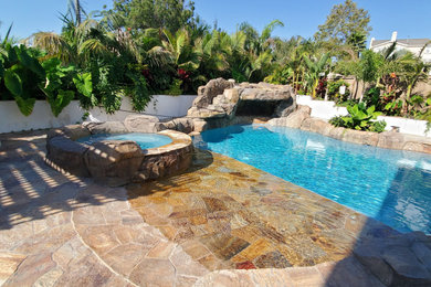 Foto de piscina natural costera grande tipo riñón en patio trasero con paisajismo de piscina y adoquines de piedra natural
