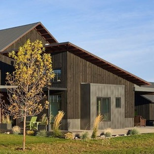 Cottage black two-story wood house exterior idea in Boise with a metal roof