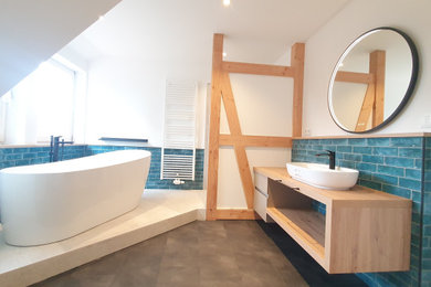 Großes Landhausstil Badezimmer mit offenen Schränken, hellbraunen Holzschränken, freistehender Badewanne, Duschnische, Wandtoilette mit Spülkasten, grünen Fliesen, Metrofliesen, schwarzer Wandfarbe, Vinylboden, Aufsatzwaschbecken, grauem Boden, offener Dusche, brauner Waschtischplatte, Einzelwaschbecken und schwebendem Waschtisch in Hannover