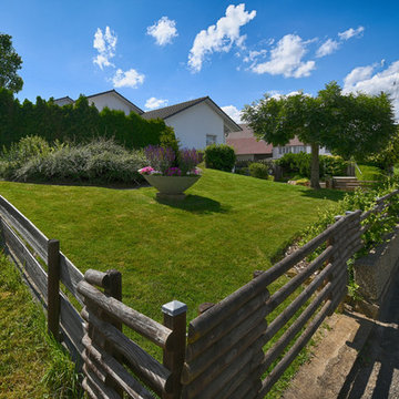 Natursteinmauern und Wasserspiel bilden großzügige und helle Gartenräume zum A