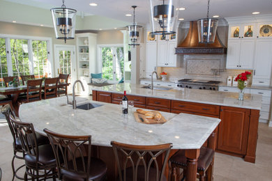 Open concept kitchen - huge l-shaped porcelain tile and brown floor open concept kitchen idea in Chicago with an undermount sink, raised-panel cabinets, white cabinets, quartzite countertops, gray backsplash, ceramic backsplash, stainless steel appliances, two islands and gray countertops
