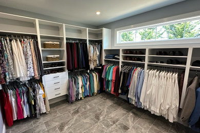 Large classic gender neutral walk-in wardrobe in Philadelphia with open cabinets, white cabinets, laminate floors and grey floors.